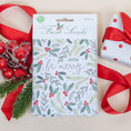 Load image into Gallery viewer, Be Merry Fresh Scents Scented Sachet flat lay with frosted branch, ribbon, and holiday wrapping
